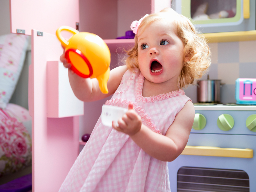 girl playing with plastic teacup