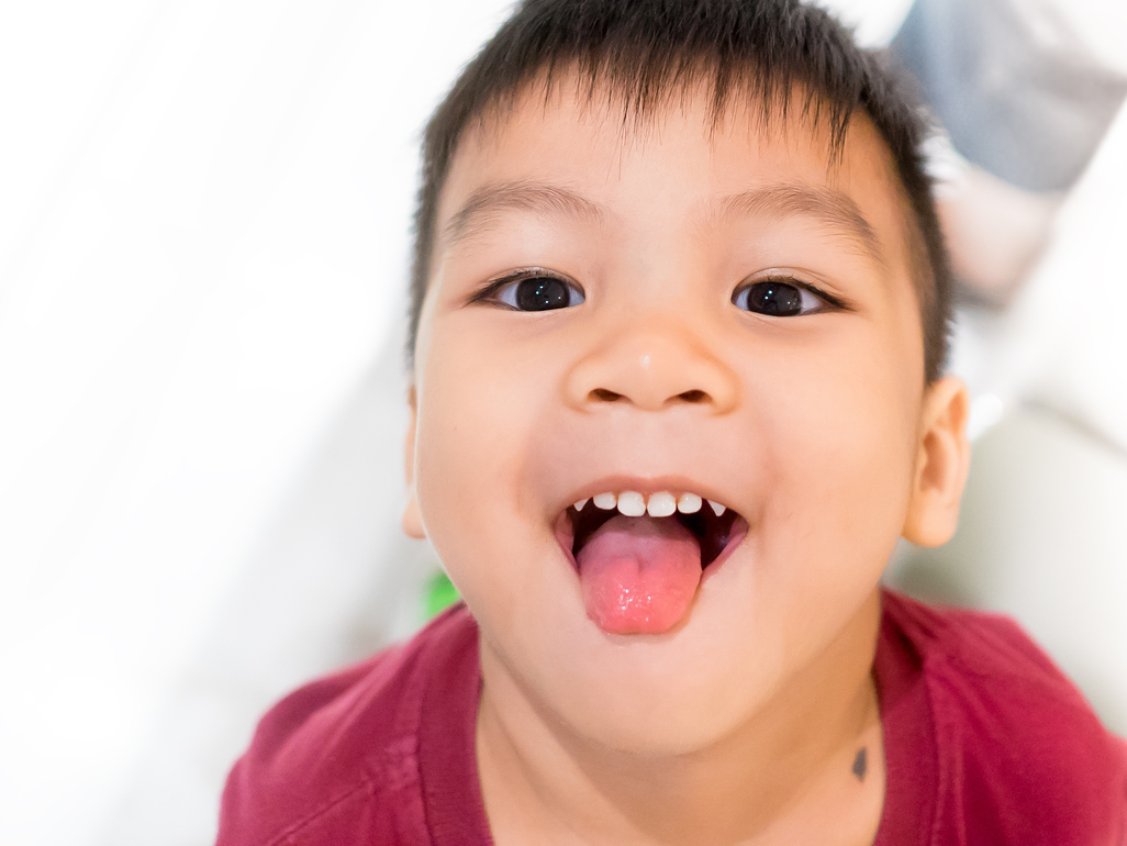 boy putting his tongue out and smiling