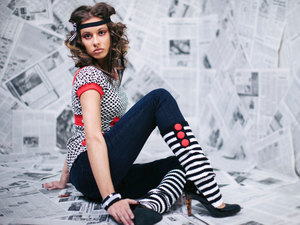 woman posing theatrically, wearing high socks, heels, and bandana