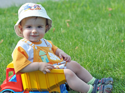 Toddler sitting in a toy truck outside