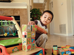 Toddler boy stacking colourful wooden block