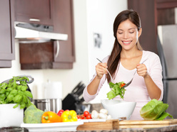 Smiling woman eating salad