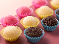 An assortment of chocolate, yellow and pink cupcakes