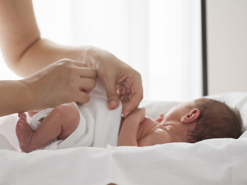 mamá poniéndole un pañal de tela al bebé