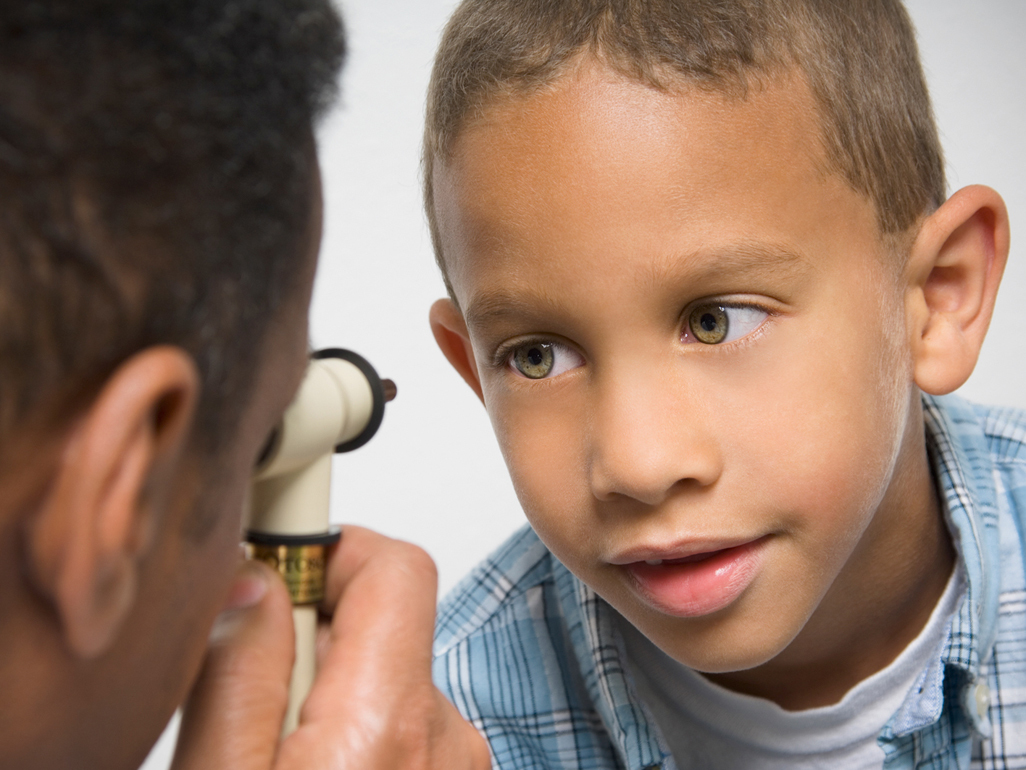 doctor looking into child's eye with a device