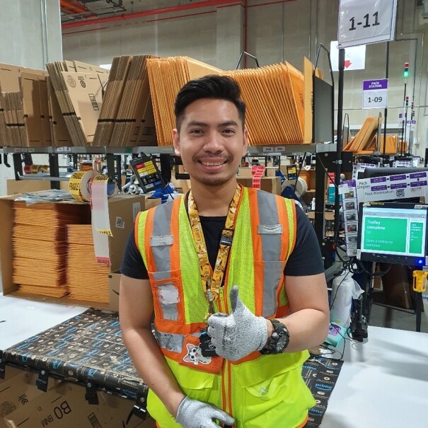 Aung Kaing giving a thumbs up in the fulfillment centre in Singapore