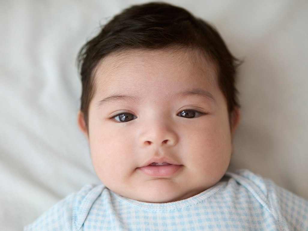 baby lying on a white sheet