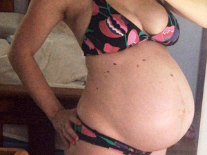 woman 37 weeks pregnant showing her belly