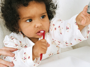 Baby girl with a toothbrush in her mouth