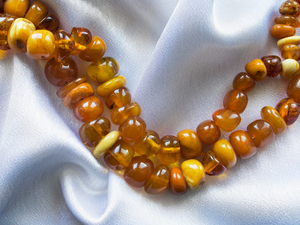 amber necklace lying on white material