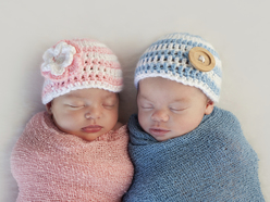 Zwei Babys in blaue und rosa Decken gewickelt