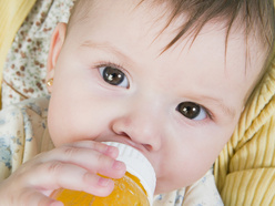 Baby trinkt aus einer Saftflasche