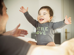 Baby mit weit ausgestreckten Armen und offenem Mund