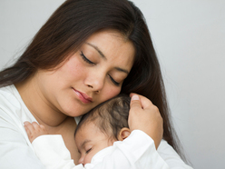 A mum holding her newborn close