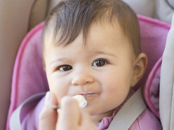 Baby in a car seat eating from a spoon