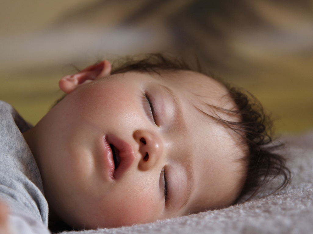 a baby asleep in her cot