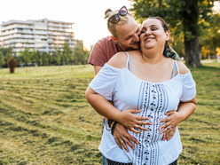 Pregnant woman getting a hug from partner