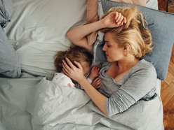 A baby and toddler sleeping in a bed together