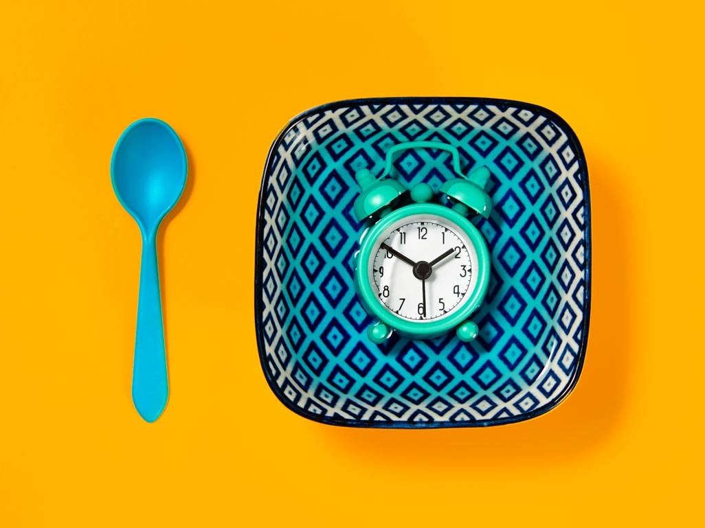 clock on empty plate representing fasting 