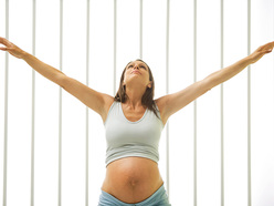 Pregnant woman stretching her arms above her head