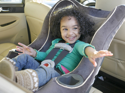 Little girl looking happy in carseat