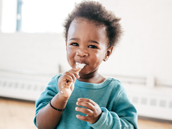 Little boy feeding himself with a spoon