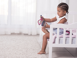 Little girl getting dressed in her room