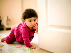 Crawling baby reaching out to close the door