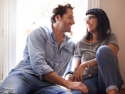 heterosexual couple casually sitting and talking and smiling