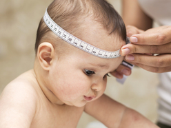 Baby having head measured