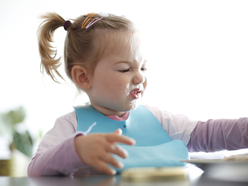 Little girl eating at highchair 