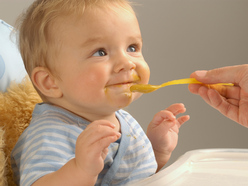 Baby being fed pureed food from a spoon