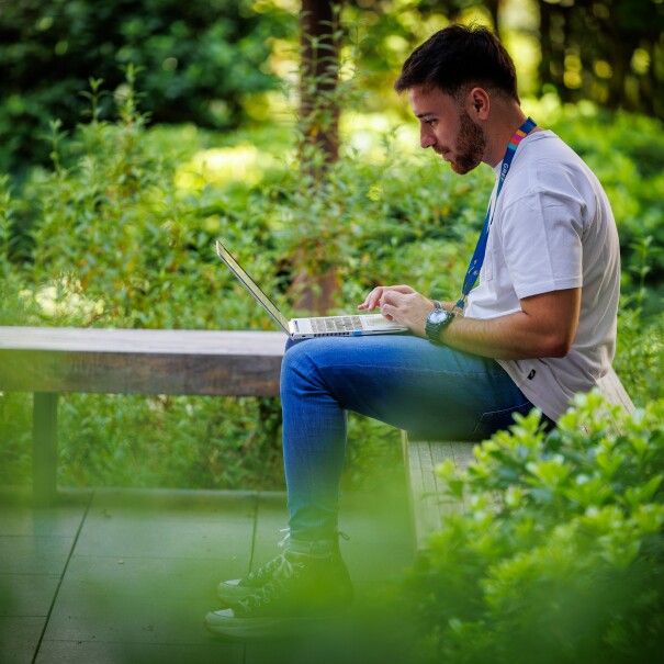 Un hombre trabajando con un ordenador en el jardin de una oficina logística de Amazon en Madrid. 