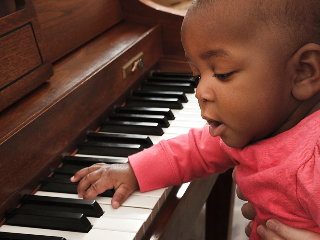 young child with hand on a piano