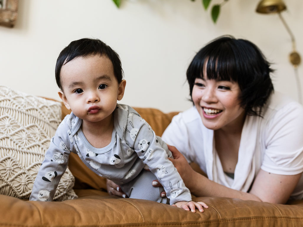 1-year-old crawling on couch with mom watching