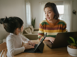 A mother and child sitting and talking at a table