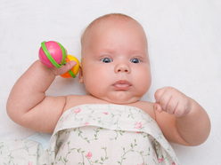 young baby holding a rattle