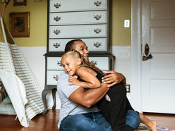 Dad sitting on floor hugging his daughter