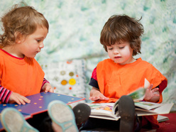 Two children looking at picture books together