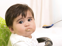 toddler being fed a meal with a spoon