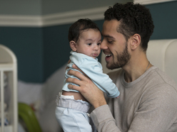 Dad cuddling tired baby