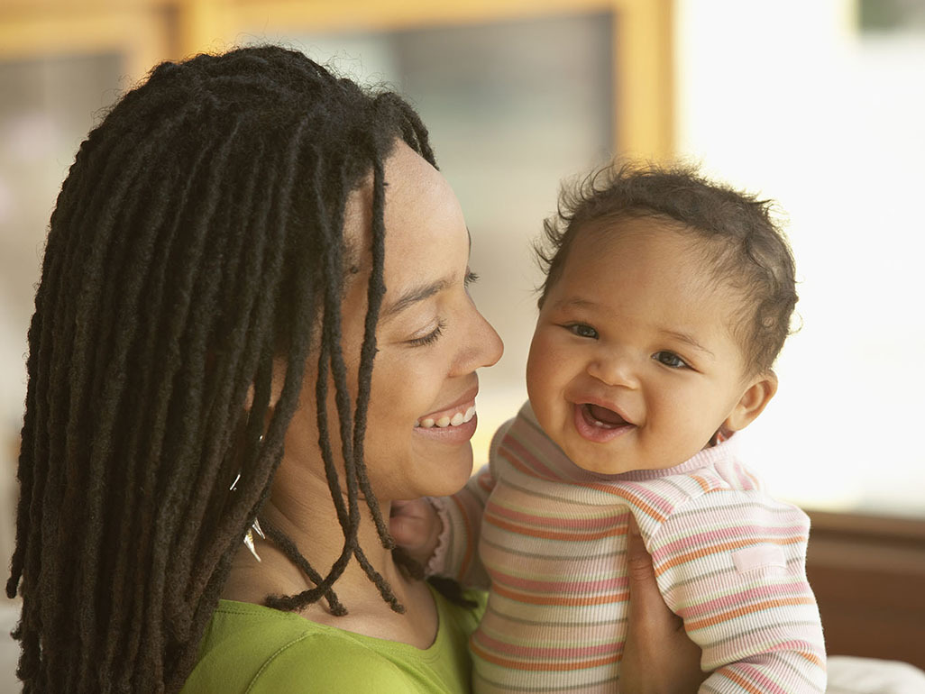 Smiling woman holding laughing baby