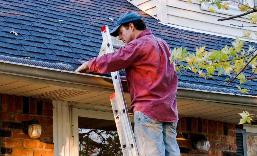 Person cleaning gutters