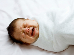 baby crying while swaddled