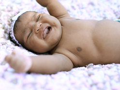 newborn crying and laying on her back