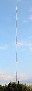 A red-and-white striped TV tower reaching tall into the sky