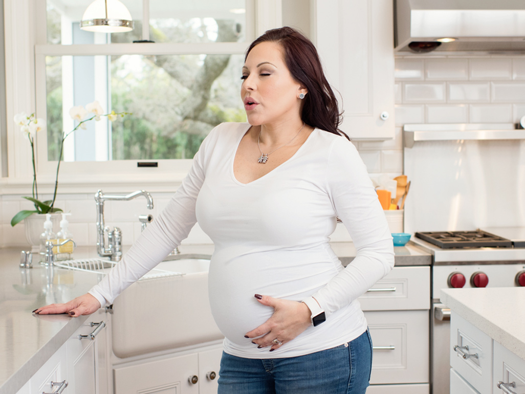 Pregnant woman holding her tummy