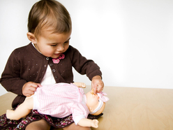 Toddler, feeding her doll.