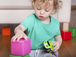 Toddler playing with brightly coloured blocks