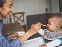 Woman feeding baby solids